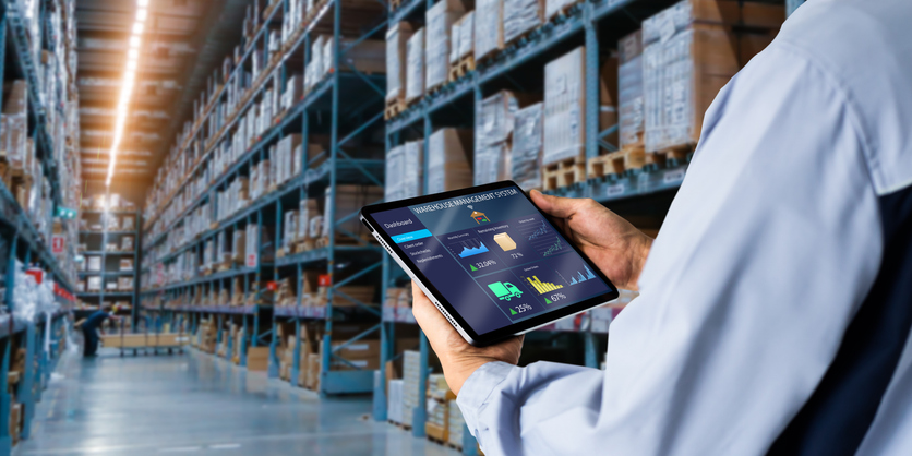 Smart Warehouse,Inventory management system concept.Manager using digital tablet,showing warehouse software management dashboard on blurred warehouse as background